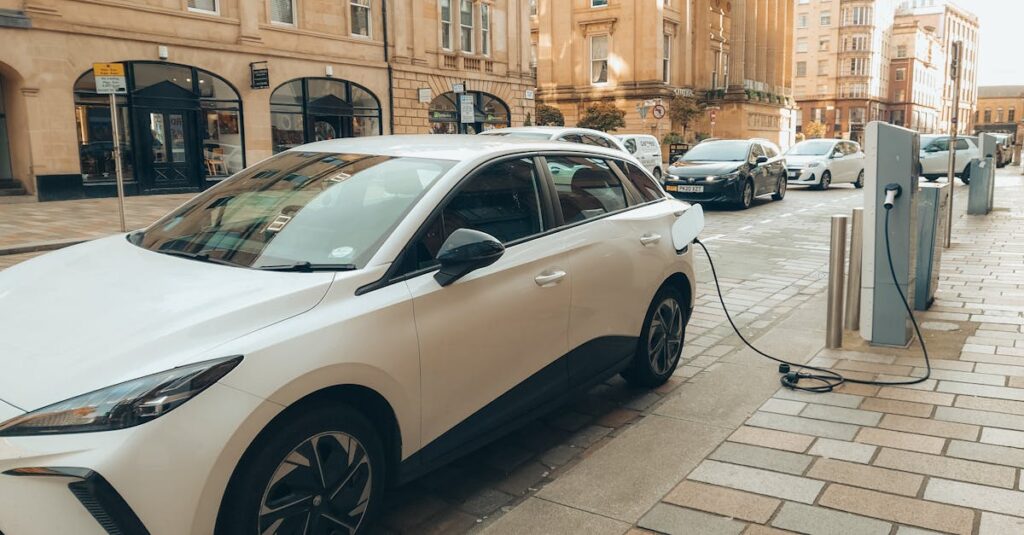 White electric car charging at a modern station on a Glasgow street.
